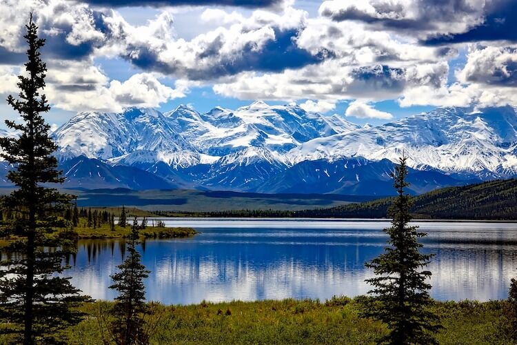 Snow capped mountains over water.