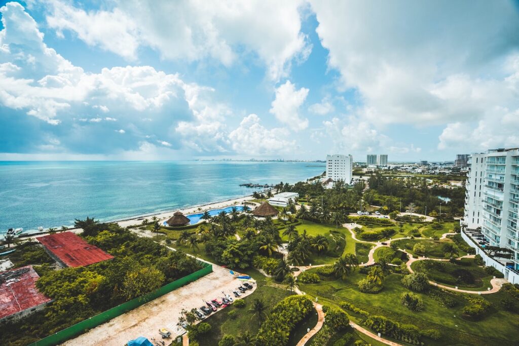 Cancun resort complex with palm trees overlooking the ocean.