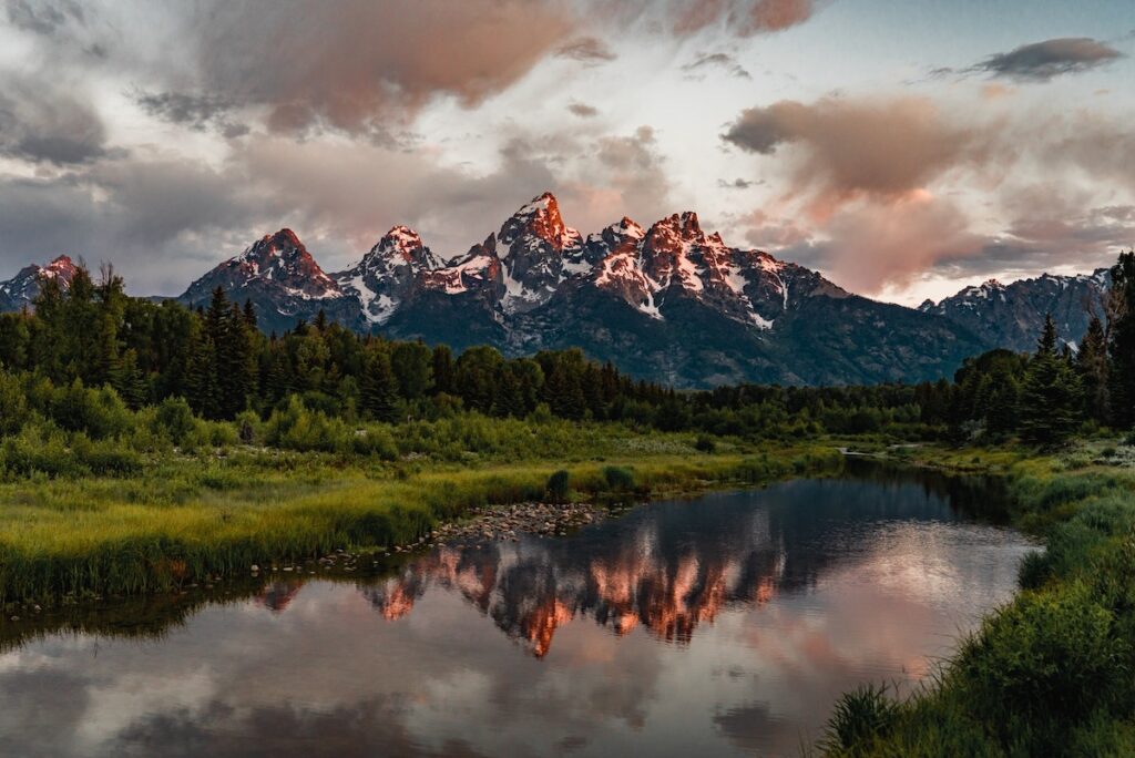 Snow capped mountains in Wyoming reflected in a clear lake.